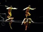 A group of circus performers performing on a tight rope during a Quinceanera dancer performance