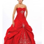 A woman in a red Quinceanera gown posing for a picture