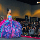 Quinceanera fashion show, a woman in a colorful dress walking down a runway