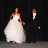 Quinceanera: A woman wearing a Quinceanera dress, a man and a woman walking on a stage