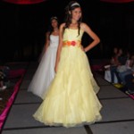 Quinceanera: A woman in a yellow gown walking down a runway