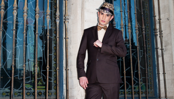 A man in a suit and bow tie standing in front of a Quinceanera venue