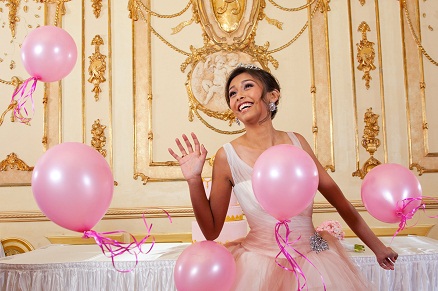 Quinceañera celebrate surrounded by pink balloons