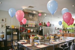 Quinceanera table with a bunch of balloons on it at COOK LA Cooking School
