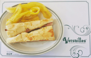 A Quinceanera themed image featuring a white plate topped with a sandwich and french fries in the breakfast San Fernando Valley.