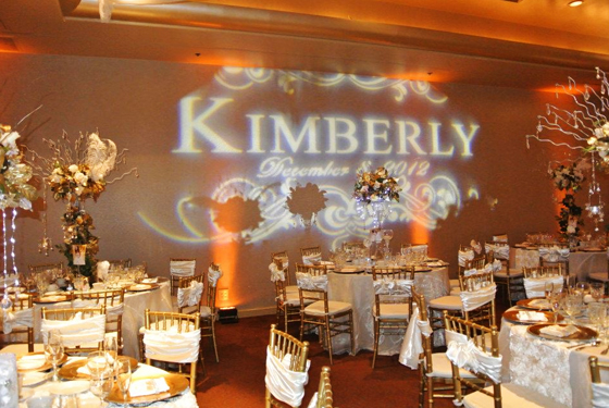 A Quinceanera celebration with a simple theme. The room is filled with lots of tables and chairs.