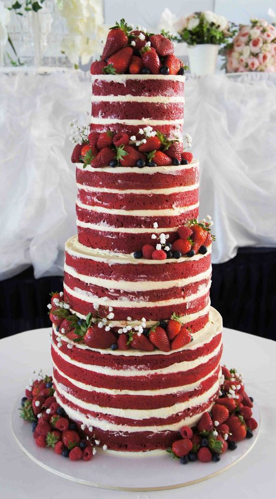 A Quinceanera themed red velvet cake designed in three tiers. The cake is decorated with strawberries and baby's breath.