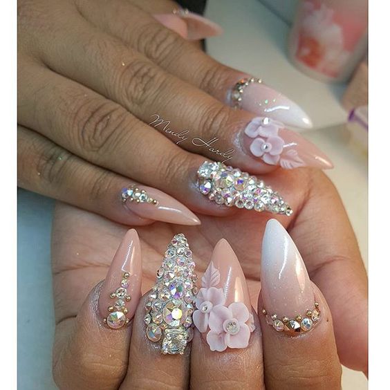 A person holding a pink and white manicure with 3D flower nail design for a Quinceanera event