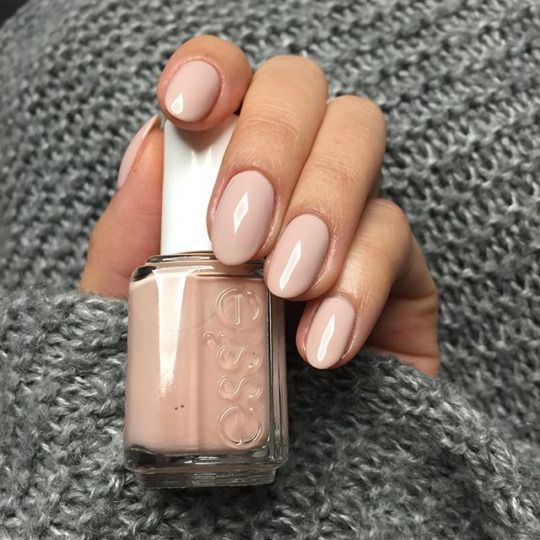A person holding a bottle of Quinceanera-themed nail polish, Essie Spin the Bottle.