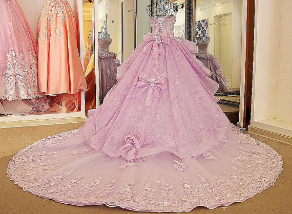 A pink Quinceanera gown is displayed in front of a mirror