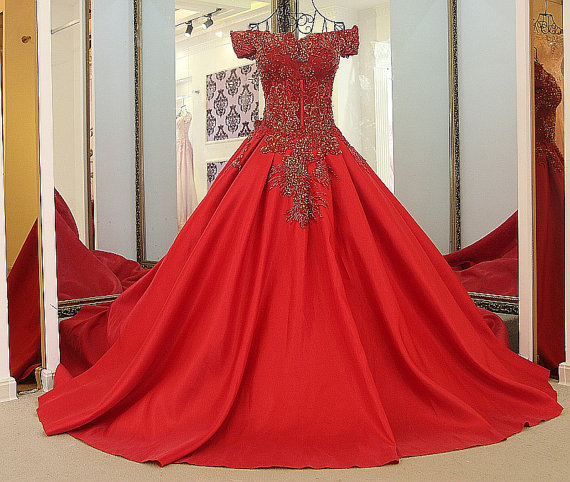 A beautiful Quinceanera gown is displayed in a mirror, featuring a stunning red dress.