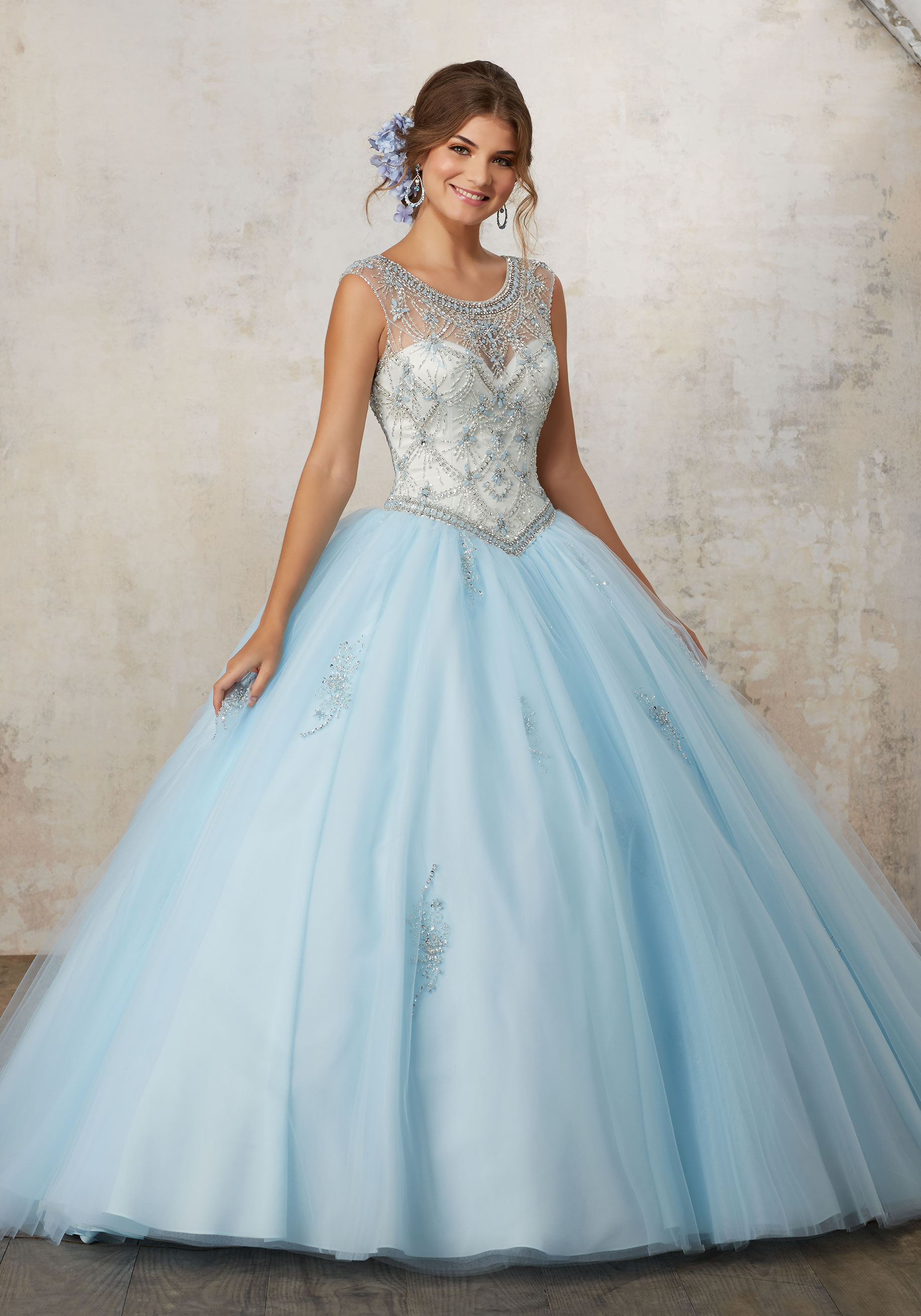 A picture of a woman in a blue ball gown posing for a picture of quinceanera dresses