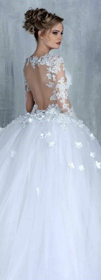 A woman wearing a gown Quinceañera dress, with a white wedding dress adorned with flowers.