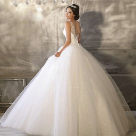 A Quinceanera dress, a woman in a Quinceanera dress standing in front of a wall