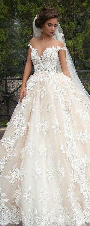 A woman wearing a Quinceanera dress with a veil for her Quinceanera celebration