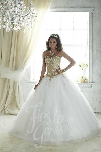 A woman wearing a white and gold Quinceanera dress