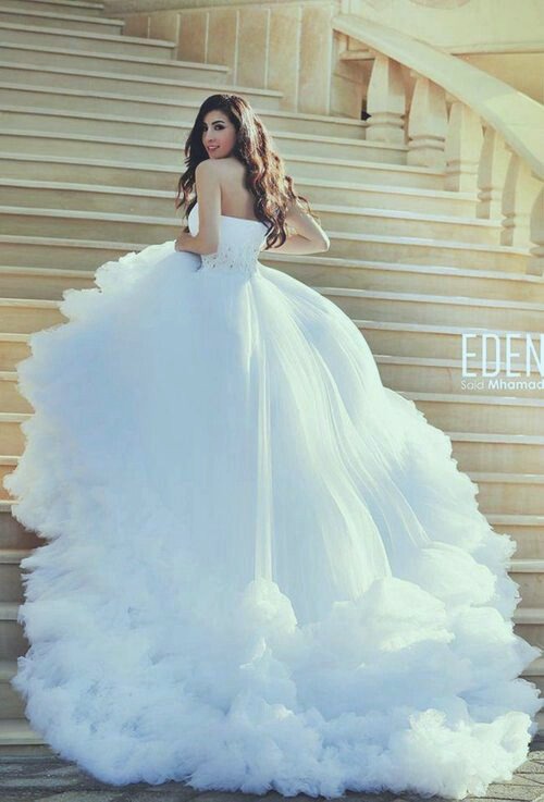 A cute woman in a Quinceanera gown standing on some stairs