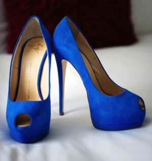 A pair of blue Quinceanera shoes sitting on a bed