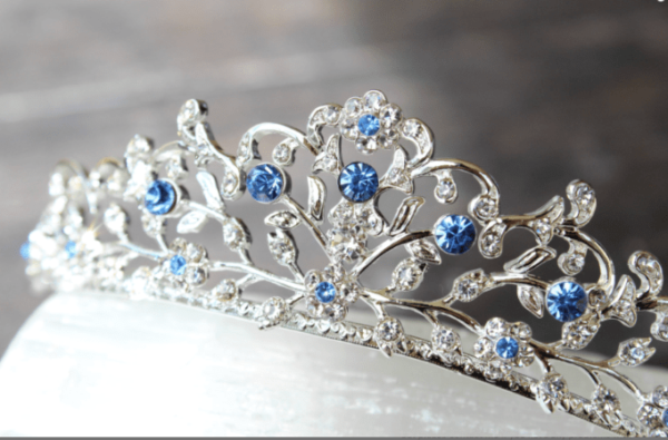 A Quinceanera blue tiara earring with blue and white crystals on it