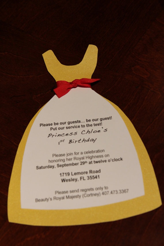 A Quinceanera-themed image featuring a paper dress on a table with a red bow