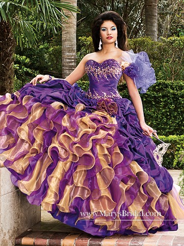 A woman wearing a purple and gold Quinceanera dress with beautifully colored hair.