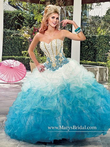 A woman wearing a blue and white Quinceanera gown posing for a picture.