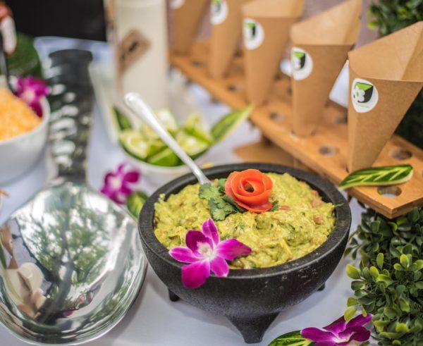 A bowl of guacamole on a table, perfect for a Quinceanera celebration meal.