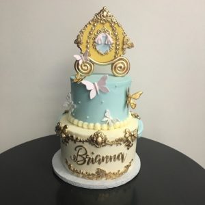 A three tiered sugar cake with a clock on top, perfect for a Quinceanera celebration.