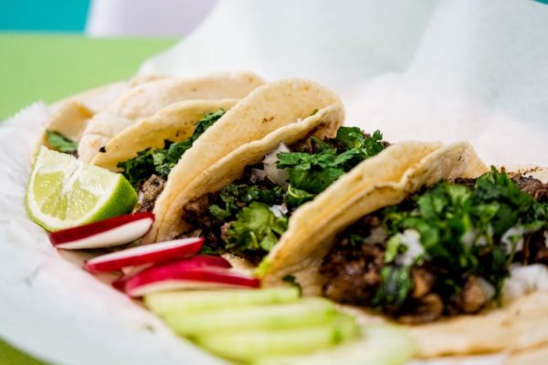 Two tacos sitting on top of a white plate. Eat to Beat Disease: The New Science of How Your Body Can Heal Itself by Dr. William Li, a book about how your body can heal itself.