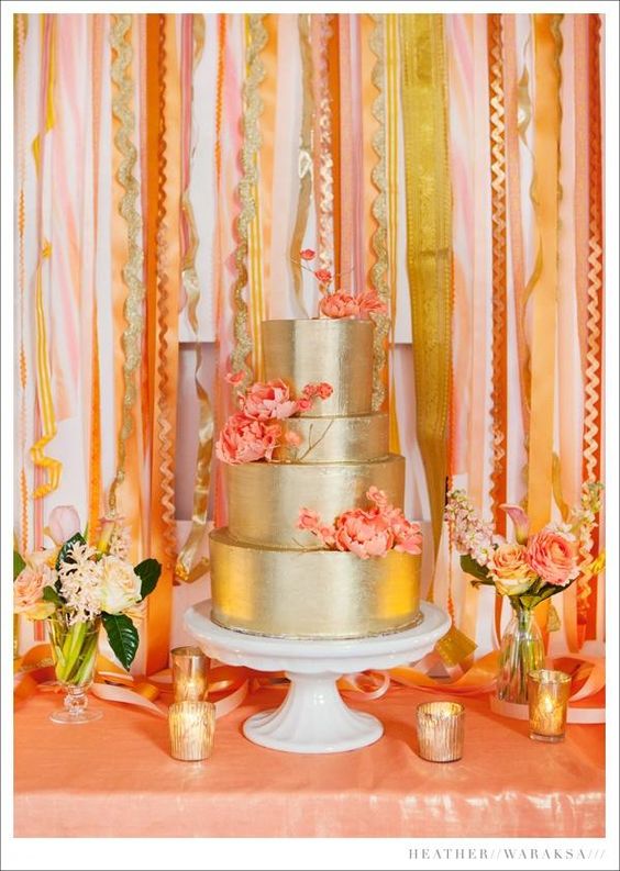 A Quinceanera celebration with a British flag wedding dress from United Kingdom and a gold wedding cake with pink flowers on a table