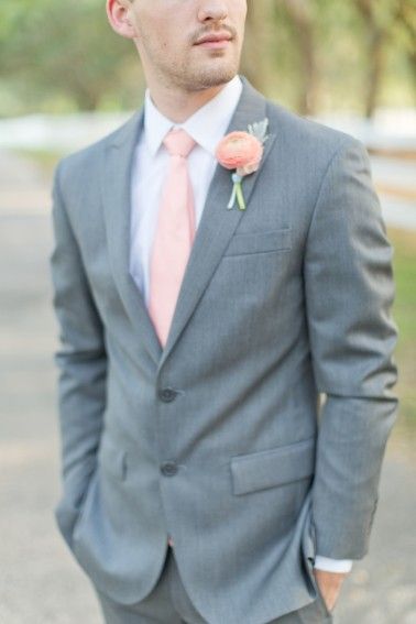 A man in a gray suit and pink tie, wearing a Quinceanera terno para chambelan.