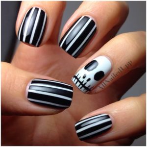 A person holding a black and white striped manicure for a Quinceanera celebration