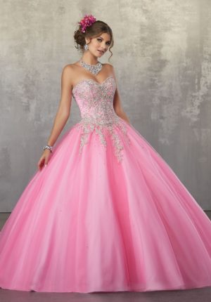 A woman wearing a pink strapless Quinceañera ball gown