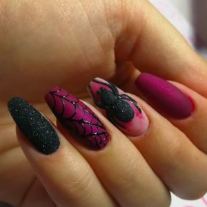 A Quinceanera themed image featuring coffin-shaped purple Halloween nails with a pink and black manicure being held by a person.