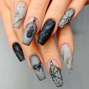 Quinceanera-themed nail sticker: A woman's hand with a black and white manicure featuring spider webs