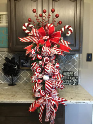 A festive Quinceanera wreath consisting of a red and white Christmas wreath on a kitchen counter