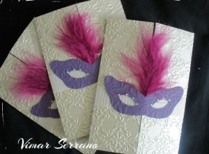A Quinceañera themed image featuring a couple of cards decorated with purple feathers.