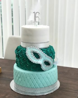 A Quinceanera cake, a three tiered cake with a dragon on top