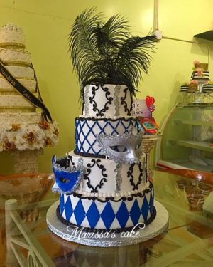 A three-tiered Quinceanera cake sitting on top of a glass table, decorated with intricate designs