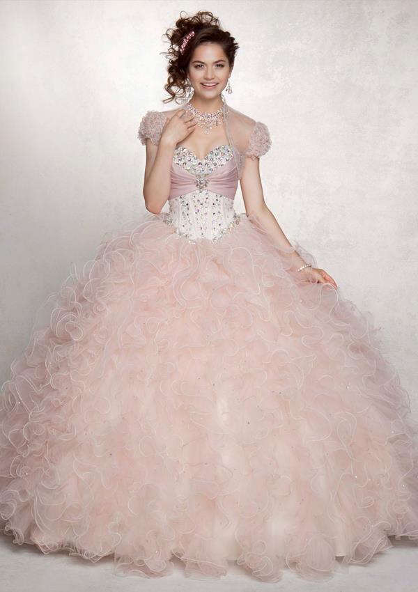 A woman in a pink Quinceañera gown posing for a picture