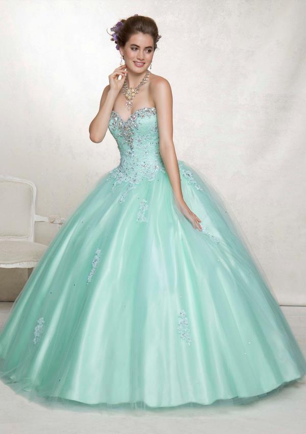 A woman in a blue sweetheart Quinceanera ball gown dress posing for a picture