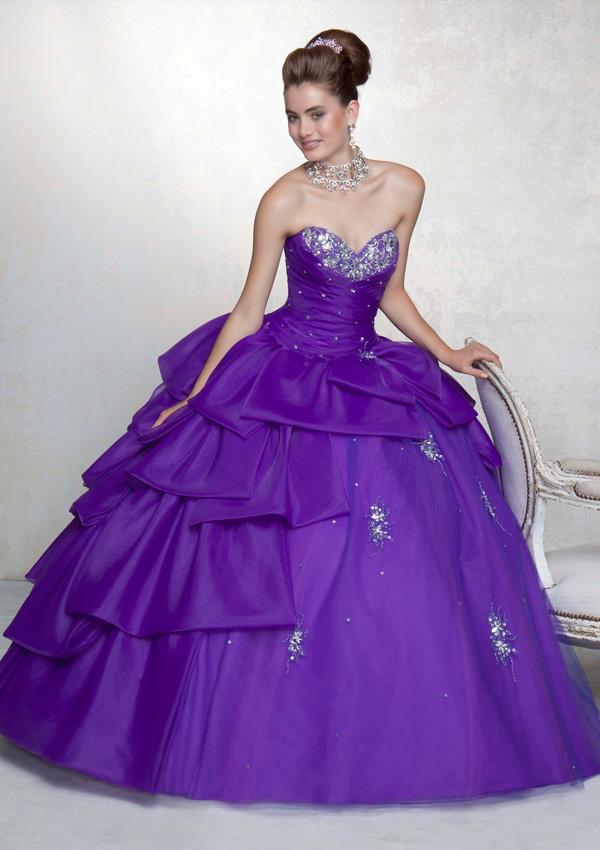 A woman in a purple Quinceanera dress sitting on a chair, wearing an enchanted ball gown