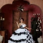 A woman wearing a black and white gown, standing in a room at the Boojum Tree Hidden Gardens for a Quinceanera celebration.