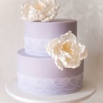 A Quinceanera cake, a close up of a three tiered cake with flowers on top
