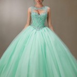 A woman in a green Quinceanera dress posing for a picture, a creation for the Quinceanera celebration