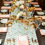 A long table is set with place settings in mint and salmon colors for a Quinceanera celebration.