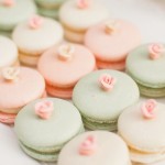 Quinceanera themed image: A white plate topped with lots of macarons in peach and mint colors with a Quinceanera invitation in the background.