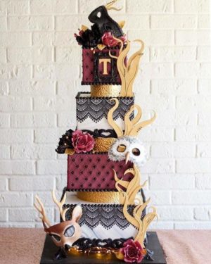 A Quinceanera cake with a masquerade theme. It is a three-tiered cake with a deer figurine on top.
