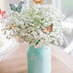 A spring themed Quinceanera with a floral design featuring a vase filled with baby's breath flowers on a table