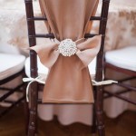 Quinceanera chair decorations, a chair with a pearl bow tied to the back of it